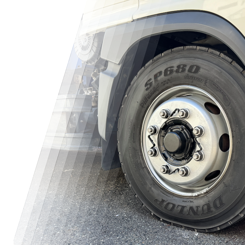 トラックのタイヤにナットチェッカーを装着した様子。比較としてチェックリンクというタイヤ脱落防止の対策品もある。